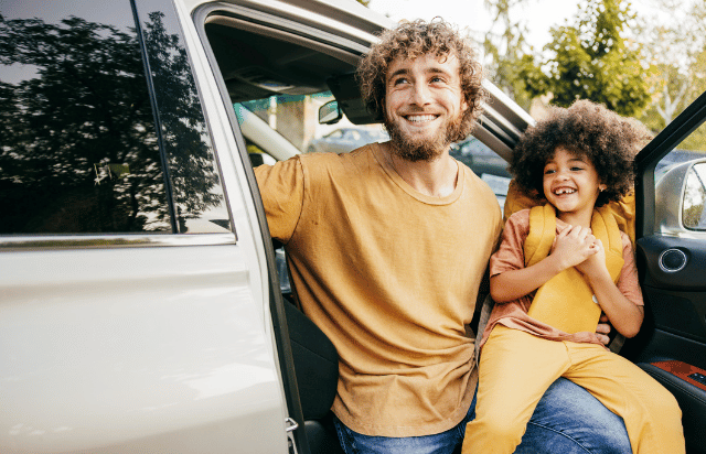 Father and daughter exiting vehicle for school drop-off