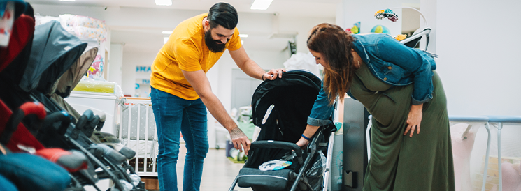 Man and woman shopping for stroller in store