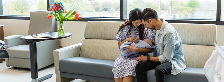 New mother and father holding newborn baby in hospital