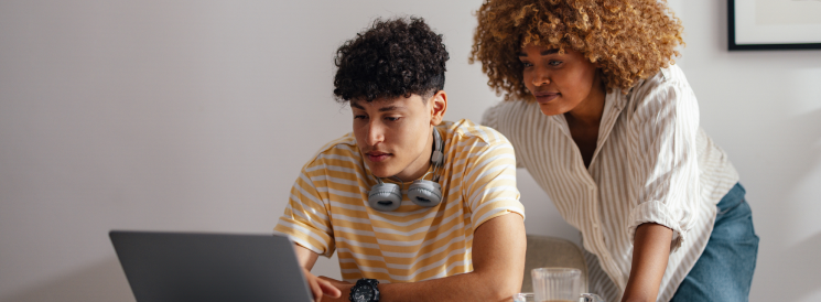 Mother and teenage son creating a budget on laptop