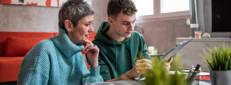 Mother and son creating budget on tablet