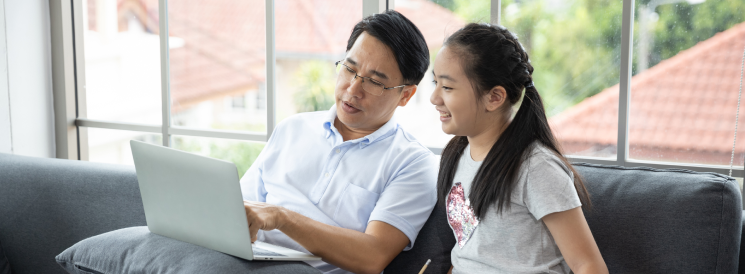 Father exploring financial options with daughter on laptop