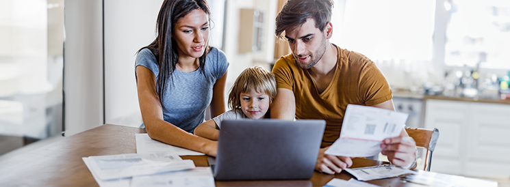 Mother and Father looking at bank accounts online with young child