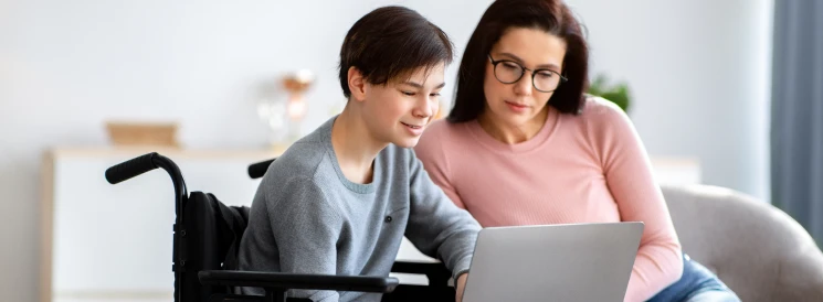 Mother and son in wheelchair browse savings options for disabilities