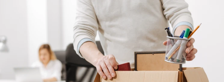 Person packing box with desk accessories