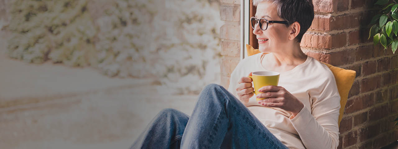 Woman holding a mug while sitting on porch