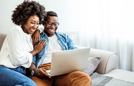 Couple on laptop initiating balance transfer to new credit card