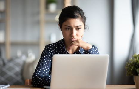 Woman reading possible scam email on laptop