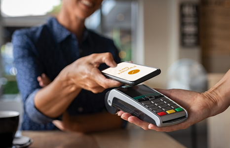 Person using phone to tap to pay at POS machine with mobile wallet